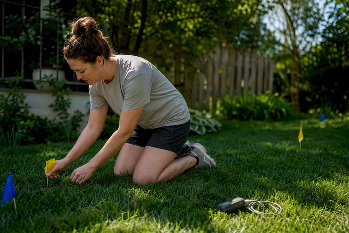 Owner placing boundary flags in backyard