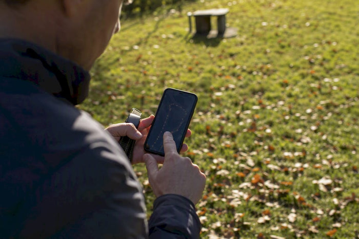 Person setting virtual dog fence boundary outdoors